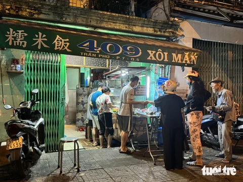 Xôi nhà xác 50 năm nức tiếng Chợ Lớn, nghe rùng rợn mà tấp nập người mua- Ảnh 6. Chủ và nhân viên quán xôi không khi nào ngơi tay vì luôn có khách đến mua - Ảnh: HỒ LAM