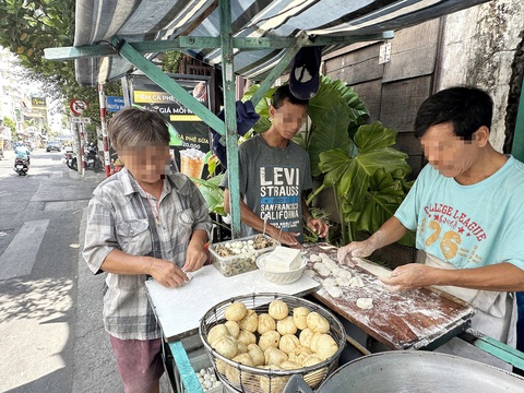 Thức ăn đường phố, quản lý thế nào?- Ảnh 3. Người bán bánh bao, bánh tiêu trên vỉa hè đường Huỳnh Tịnh Của (quận 3, TP.HCM) bên hông Trường tiểu học Nguyễn Thái Sơn không sử dụng găng tay khi chế biến - Ảnh: THẢO THƯƠNG