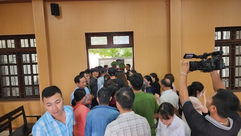 Nhận hối lộ làm giả kết luận giám định, cựu giám đốc trung tâm pháp y lãnh án tù- Ảnh 3. Người thân của các bị cáo ùa theo khi các bị cáo được đưa ra xe, dẫn giải về trại giam - Ảnh: TRẦN MAI
