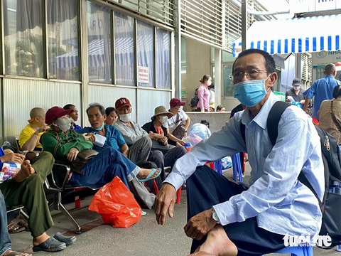 Người bệnh mạn tính mỏi mòn chờ đợi lãnh thuốc bảo hiểm y tế- Ảnh 1. Người bệnh mạn tính ngồi bên ngoài chờ đợi đến lượt mình lãnh thuốc bảo hiểm y tế tại Bệnh viện Chợ Rẫy (quận 5) - Ảnh: NGỌC NHI