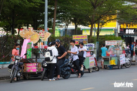 Thức ăn đường phố, hàng rong: Thấy thì 'dơ dơ' nhưng cứ tặc lưỡi cho qua- Ảnh 11. Hàng rong với đủ các loại thức ăn, nước uống... xếp hàng dài trước cổng KTX khu B (khu đô thị Đại học Quốc gia TP.HCM) chiều 9-5
