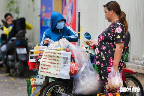 Thức ăn đường phố, hàng rong: Thấy thì 'dơ dơ' nhưng cứ tặc lưỡi cho qua- Ảnh 8. Bánh tráng trộn trở thành món ăn vặt ưa thích của nhiều người. Tuy nhiên, dưới thời tiết nắng nóng, bánh đựng trong túi ni lông cùng nước sốt rất dễ bị ôi, thiu, ẩm mốc