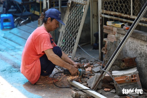 Người dân quận 3 hiến hàng ngàn mét vuông đất mở rộng hẻm- Ảnh 6. Nhiều hộ gia đình trong hẻm 240 Cách Mạng Tháng 8 sáng nay 1-6 đã tiến hành tháo dỡ các công trình trước nhà - Ảnh: NGỌC QUÝ