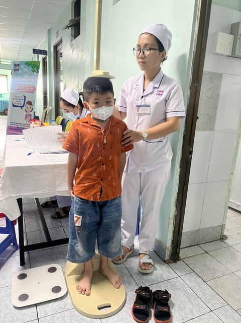 Hàng ngàn cha mẹ lo lắng trẻ chậm tăng trưởng chiều cao đưa trẻ đi khám- Ảnh 1. Một bà mẹ ở TP.HCM lo lắng con trai chậm phát triển chiều cao đã đưa con đến Bệnh viện Nguyễn Tri Phương để khám trong ngày 1-6 - Ảnh: THÙY DƯƠNG
