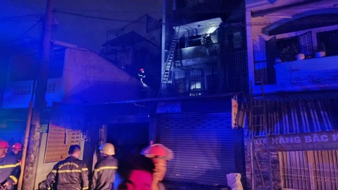Vụ cháy nhà tại quận 10: 3 anh em ruột bị ngạt khói, 2 bé phải thở máy- Ảnh 2. Lực lượng cảnh sát PCCC cứu nhiều người trong căn nhà cháy - Ảnh: NGỌC KHẢI