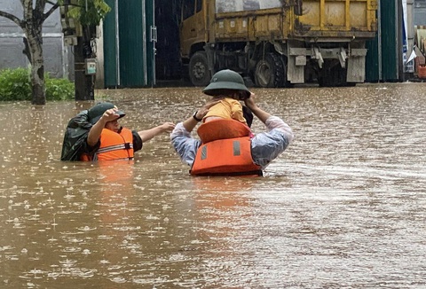 Lũ ở Hà Giang lớn nhất trong 30 năm, người dân không kịp trở tay- Ảnh 1. Lực lượng cứu hộ cứu nạn đưa một em bé ra khỏi khu vực ngập sâu ở TP Hà Giang sáng 10-6 - Ảnh: THU PHƯƠNG