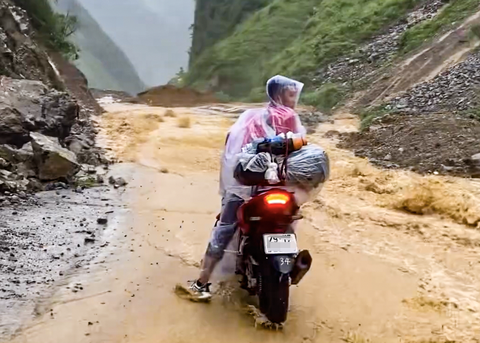 Đi Hà Giang 'chữa lành', du khách mắc kẹt do lũ- Ảnh 1. Một du khách kẹt giữa dòng nước lũ - Ảnh: K.N.