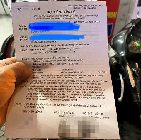 Cầm đồ, cần lưu ý gì để tránh 'bẫy' tín dụng đen?- Ảnh 3. Khách xem lại hợp đồng cầm xe máy không ghi mức lãi suất - Ảnh: YẾN TRINH