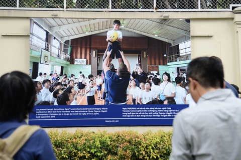 Hai hậu vệ môm bóng bầu dục người Pháp nâng một em nhỏ trong buổi giao lưu với các học sinh trường Taguma Higashi ở Kumamoto, nhân dịp Giải vô địch Bóng bầu dục ilên hiệp thế giới diễn ra ở Nhật Bản. Triển lãm của Tổng Lãnh sự quán Pháp muốn tôn vinh như những khoảnh khắc sẻ chia và tình hữu nghị mà các vận động viên, đội tuyển của họ cũng như công chúng nói chung đã trải qua giống như trong bức ảnh này - Ảnh: HẢI QUỲNH Hai hậu vệ môn bóng bầu dục người Pháp nâng một em nhỏ trong buổi giao lưu với các học sinh Trường Taguma Higashi ở Kumamoto, nhân dịp Giải vô địch bóng bầu dục liên hiệp thế giới diễn ra ở Nhật Bản. Triển lãm của Tổng lãnh sự quán Pháp muốn tôn vinh những khoảnh khắc sẻ chia và tình hữu nghị mà các vận động viên, đội tuyển của họ cũng như công chúng đã trải qua như trong bức ảnh này - Ảnh: HẢI QUỲNH