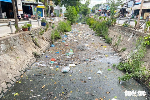 Kênh 19-5: Mới dọn chưa đầy tháng rác lại ngập ngụa, phường phải tiếp tục ra quân- Ảnh 2. Mặt kênh 19-5 phủ kín bởi rác thải, túi ni lông, đồ ăn dư thừa bốc mùi hôi thối nồng nặc - Ảnh: TIẾN QUỐC