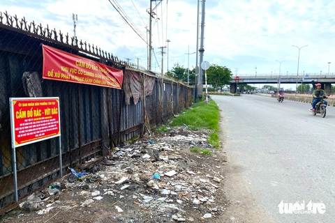Kênh 19-5: Mới dọn chưa đầy tháng rác lại ngập ngụa, phường phải tiếp tục ra quân- Ảnh 7. Một điểm đã được đơn vị quản lý dọn dẹp, cắm biển cấm đổ dọc tuyến quốc lộ 1 - Ảnh: TIẾN QUỐC