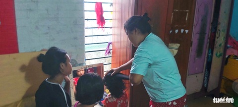 Người dưng chạy đôn chạy đáo giúp người mẹ đơn thân và 4 con không còn ‘vô danh’- Ảnh 1. Chị Miệp chải tóc cho các con - Ảnh: ĐOÀN CƯỜNG