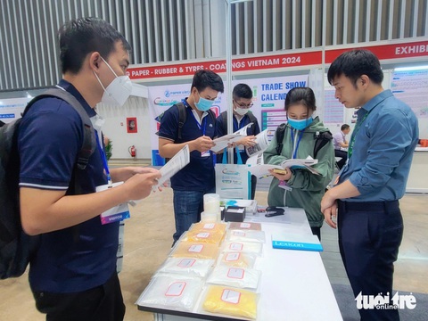 350 doanh nghiệp ngành sơn phủ, giấy, cao su và nhựa ‘chào hàng’ tại triển lãm quốc tế- Ảnh 2. Khách hàng tìm hiểu các loại hạt nhựa tại triển lãm - Ản: NHẬT XUÂN