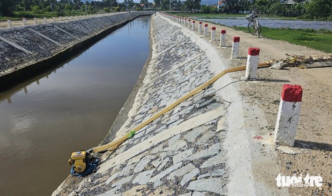 Kênh được kiên cố không đủ nước đưa về ruộng?- Ảnh 1. Người dân thôn Thạnh Mỹ phải dùng máy bơm nước từ con kênh chính để dẫn nước vào ruộng - Ảnh: MINH CHIẾN