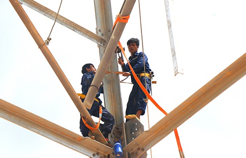 Công nhân đu dây, lắp ghép thanh sắt ở cột vị trí 35 đường dây 500kV mạch 3 - Ảnh: LÊ MINH Công nhân đu dây, lắp ghép thanh sắt ở cột vị trí 35 đường dây 500kV mạch 3 - Ảnh: LÊ MINH
