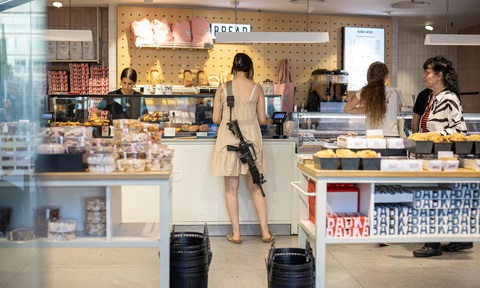 Trong tiệm bánh Tel Aviv Một phụ nữ khoác theo khẩu súng trường khi đi vào mua hàng ở một tiệm bánh tại thành phố Tel Aviv của Israel. (Marko Djurica/Reuters) Một phụ nữ khoác theo khẩu súng trường khi đi vào mua hàng ở một tiệm bánh tại thành phố Tel Aviv của Israel. (Marko Djurica/Reuters)