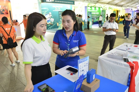 Giao dịch không tiền mặt đã rất phổ biến, cần tập trung bảo đảm an toàn cho người sử dụng- Ảnh 6. Nhân viên của VNPAY tư vấn máy pos để thanh toán bằng các dịch vụ của VNPAY và của các ngân hàng - Ảnh: QUANG ĐỊNH