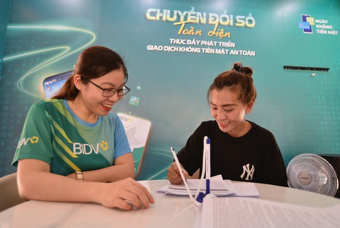 Giao dịch không tiền mặt đã rất phổ biến, cần tập trung bảo đảm an toàn cho người sử dụng- Ảnh 5. Khách hàng mở thẻ ngân hàng BIDV tại lễ hội sáng 14-6 - Ảnh: QUANG ĐỊNH
