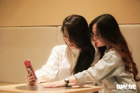 Người trẻ Hà Nội xếp hàng từ 4h sáng để uống cà phê, có người chuẩn bị từ 0h- Ảnh 4. Bạn Trần Thị Nguyệt và bạn Kim Nguyễn Việt Hằng chuẩn bị từ 12h đêm để đi cà phê - Ảnh: PHẠM TUẤN