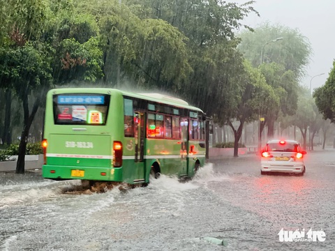 Chiều nay mưa lớn, TP.HCM, Bình Dương xuất hiện mưa đá- Ảnh 12. Xe buýt chạy qua tạo thành sóng nước trên đường Lê Lai, quận 1 - Ảnh: LÊ THÀNH HUY