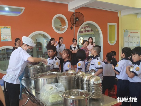 TP.HCM đề xuất tăng trần tiền suất ăn bán trú lên 40.000 đồng- Ảnh 1. Học sinh Trường tiểu học Nguyễn Bỉnh Khiêm, quận 1, TP.HCM xếp hàng lấy thức ăn trong bữa trưa bán trú - Ảnh: BẢO TRÂN