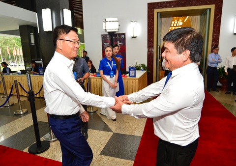 Giao dịch không tiền mặt đã rất phổ biến, cần tập trung bảo đảm an toàn cho người sử dụng- Ảnh 2. Ông Lê Thành Long - Uỷ viên Ban chấp hành Trung ương Đảng, Phó Thủ tướng Chính phủ (trái), bắt tay ông Lê Thế Chữ - Tổng biên tập Báo Tuổi Trẻ, tại hội thảo - Ảnh: QUANG ĐỊNH