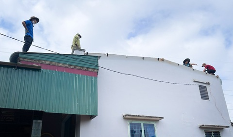 Dông lốc bất ngờ tại Gia Lai làm tốc mái hàng chục nhà dân- Ảnh 6. Người dân lợp lại mái tôn bị thổi bay ngày 15-6 - Ảnh: Đ.T.