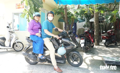 Ngày vui nhất đời của người mẹ Xtiêng đơn thân và 4 con thơ- Ảnh 5. Sau khi xong thủ tục, luật sư Việt chở chị Miệp về chỗ rửa chén bát thuê - Ảnh: ĐOÀN CƯỜNG