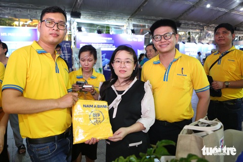 Sôi động các chương trình của Nam A Bank tại Lễ hội Không tiền mặt- Ảnh 3. Khách hàng tìm hiểu mở thẻ và nhận quà tặng tại gian hàng Nam A Bank ngày 15-6 - Ảnh: PHƯƠNG QUYÊN