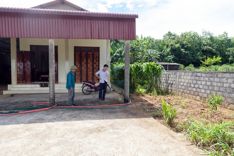 Đất đấu giá một đường, sổ đỏ một nẻo- Ảnh 1. Một phần ngôi nhà kiên cố của ông Bình (phải) nằm trên đất của ông Sơn - Ảnh: HOÀNG TÁO