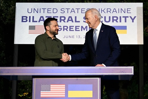 Hiểu thêm về 2 thỏa thuận an ninh lớn với Ukraine- Ảnh 1. Tổng thống Mỹ Joe Biden (phải) và người đồng cấp Ukraine Volodymyr Zelensky bắt tay sau khi ký thỏa thuận an ninh song phương bên lề Hội nghị thượng đỉnh G7 ở Ý hôm 13-6 - Ảnh: AFP