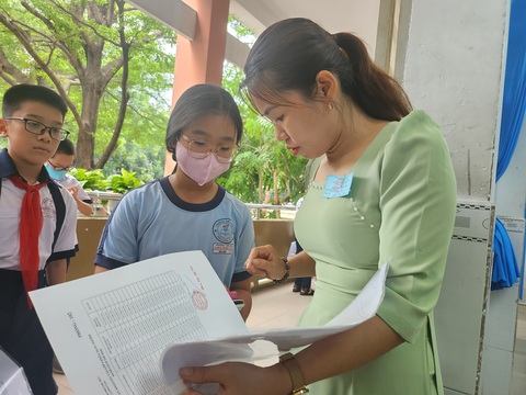 Thủ Đức công bố đề khảo sát vào lớp 6- Ảnh 1. Thí sinh làm thủ tục trước khi khảo sát vào lớp 6 tại điểm Trường THCS Bình Thọ, TP Thủ Đức sáng 15-6 - Ảnh: N.Q.