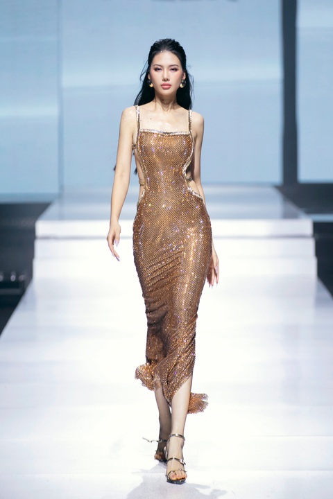 Bùi Quỳnh Hoa 'đại náo' sàn catwalk Vietnam International Fashion Week 2024- Ảnh 7. Khoác lên mình thiết kế vàng được làm từ chất liệu sequin ánh kim lấp lánh, nàng hậu như hóa thân thành một quý cô hào nhoáng trong bữa tiệc. Chiếc váy hai dây hở lưng cùng phần thân váy bó sát giúp người đẹp khoe vóc dáng cực quyến rũ. Dù gặp phải sự cố tuột dây giày nhưng Miss Universe Vietnam 2023 cho thấy sự chuyên nghiệp của mình khi vẫn sải bước rất tự tin, thể hiện đúng tinh thần của BST.