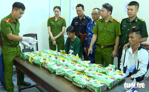 Bắt hai vợ chồng vận chuyển 30kg ma túy để lấy 200 triệu đồng tiền công- Ảnh 1. Hai nghi phạm (ngồi) vận chuyển 30kg ma túy bị công an bắt giữ - Ảnh: L.M.
