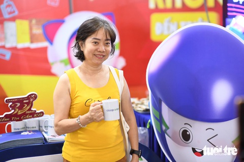 Siêu thị online Co.opmart xuống phố cùng hàng ngàn quà tặng- Ảnh 2. Khách chụp hình lưu niệm với phần quà nhận được. Đây là cơ hội để nhà bán lẻ tiếp cận người tiêu dùng mới - Ảnh: QUANG ĐỊNH