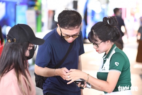 'Lễ hội Không tiền mặt đưa hình ảnh Vietcombank thêm gần gũi với khách hàng'- Ảnh 3. Nhân viên Vietcombank hướng dẫn người dân thanh toán online để uống cà phê 0 đồng - Ảnh: QUANG ĐỊNH