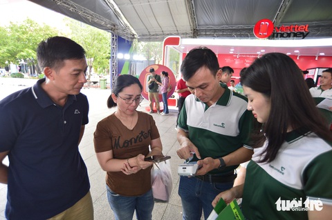 'Lễ hội Không tiền mặt đưa hình ảnh Vietcombank thêm gần gũi với khách hàng'- Ảnh 5. Người dân trải nghiệm các dịch vụ của Vietcombank vào chiều 16-6 - Ảnh: QUANG ĐỊNH