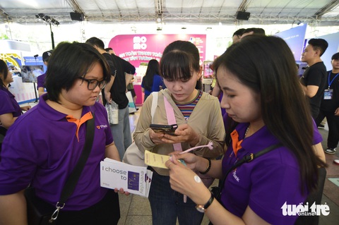 Bất ngờ khi được in hình lên thẻ ngân hàng TPBank- Ảnh 2. Nhân viên TPBank bận rộn hướng dẫn khách tham quan mở thẻ, trải nghiệm dịch vụ ngân hàng - Ảnh: QUANG ĐỊNH
