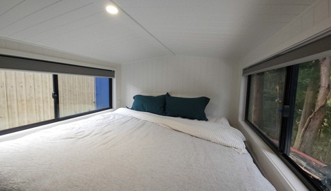 The Outlander: Nhà di động dạng thùng container có bánh xe, nội thất như khách sạn- Ảnh 13. Phòng ngủ gác xép được thiết kế tối giản với điểm nhấn là chiếc giường cỡ siêu lớn, hai bên là cửa sổ lớn đón ánh sáng tự nhiên - Ảnh: AutoEvolution