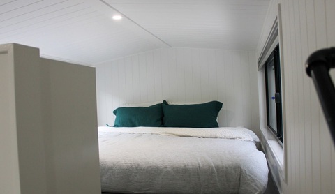 The Outlander: Nhà di động dạng thùng container có bánh xe, nội thất như khách sạn- Ảnh 14. Bức tường ngăn cách một phần giữa phòng ngủ và khu vực sinh hoạt chung vừa giúp tăng cường sự riêng tư, vừa là giải pháp lưu trữ đồ đạc hiệu quả và là nơi treo TV. Hệ thống đèn LED và ổ cắm điện là những tiện nghi duy nhất được trang bị thêm trong phòng ngủ - Ảnh: AutoEvolution