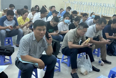 TP.HCM: Xếp hàng từ tối hôm trước mua hồ sơ cho con vào lớp 1- Ảnh 4. Phụ huynh mang căn cước công dân và giấy khai sinh, mang theo bánh và nước vào bên trong để chờ mua hồ sơ cho con vào lớp 1 - Ảnh: PHCC