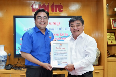 Chủ tịch Phan Văn Mãi thăm Tuổi Trẻ: 'Lễ hội Không tiền mặt phải là sự kiện thường xuyên của TP.HCM'- Ảnh 5. Bí thư Thành đoàn TP.HCM Ngô Minh Hải trao thư chúc mừng cho Tổng biên tập Lê Thế Chữ - Ảnh: HỮU HẠNH