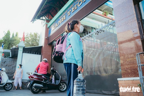 Học sinh một trường tiểu học tại TP.HCM cả năm còng lưng mang nước đến trường- Ảnh 1. Học sinh vừa phải mang cặp sách nặng vừa mang theo bình nước lớn để uống trong mùa nắng nóng tại Trường tiểu học Hanh Thông, quận Gò Vấp - Ảnh: THANH HIỆP