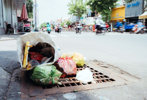 Vứt rác ra sông rạch, ta tự hại mình- Ảnh 3. Người dân vứt rác ngay trên miệng cống thoát nước trên đường Quang Trung, quận Gò Vấp - Ảnh: THANH HIỆP