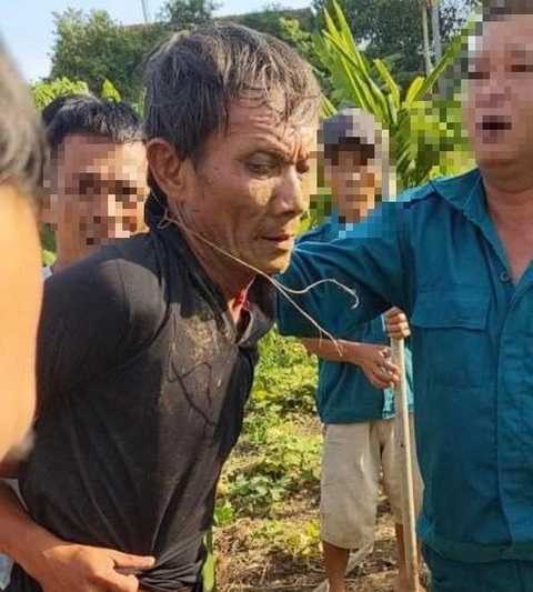 Vụ án kinh hoàng ở Quảng Ngãi: 2 vợ chồng bị giết, 2 con nhỏ bị thương- Ảnh 2. Lê Đình Thiết (áo đen), nghi phạm gây ra vụ án, bị bắt giữ - Ảnh: NGƯỜI DÂN CUNG CẤP