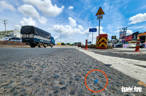 Đinh nhọn 'tái xuất' trên quốc lộ 1, đoạn lên cầu vượt An Sương- Ảnh 2. Một miếng đinh hình thoi nằm trên quốc lộ 1 đoạn lên cầu vượt An Sương - Ảnh: NGỌC KHẢI