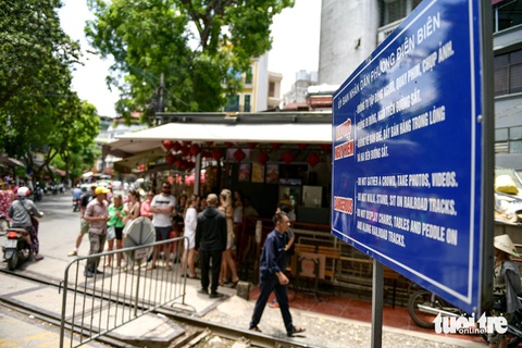 Biển cảnh báo bằng cả tiếng Việt và tiếng Anh được bố trí trước các đoạn đường tàu - Ảnh: NAM TRẦN Biển cảnh báo bằng cả tiếng Việt và tiếng Anh được bố trí trước các đoạn đường tàu - Ảnh: NAM TRẦN