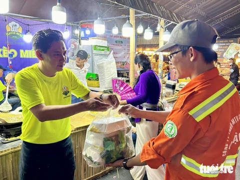 Biển người về đường Lê Lợi trải nghiệm không gian ẩm thực dịp cuối tuần- Ảnh 2. Anh Khải đã làm thêm bánh xèo 20 cái tặng cho bảo vệ, nhân viên vệ sinh làm việc tại không gian ẩm thực - Ảnh: T.T.D.