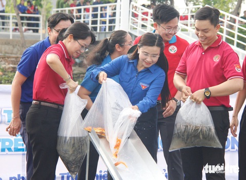 Thiếu nhi TP.HCM vui chơi, nhận quà trong ngày cao điểm vì đàn em- Ảnh 4. Phó chủ tịch UBND TP.HCM Trần Thị Diệu Thúy và Bí thư Trung ương Đoàn Nguyễn Phạm Duy Trang cùng thả cá giống tại lưu vực sông Sài Gòn - Ảnh: CÔNG TRIỆU