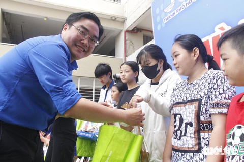 Thiếu nhi TP.HCM vui chơi, nhận quà trong ngày cao điểm vì đàn em- Ảnh 5. Anh Ngô Minh Hải, bí thư Thành Đoàn TP.HCM, trao quà cho con công nhân khó khăn tại phường An Phú - Ảnh: CÔNG TRIỆU